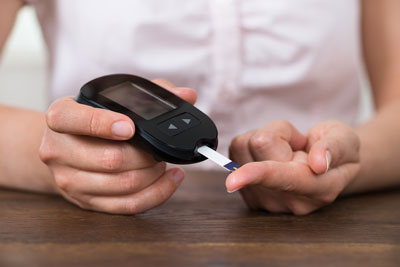 A close up view of a person using a blood-glucose monitor