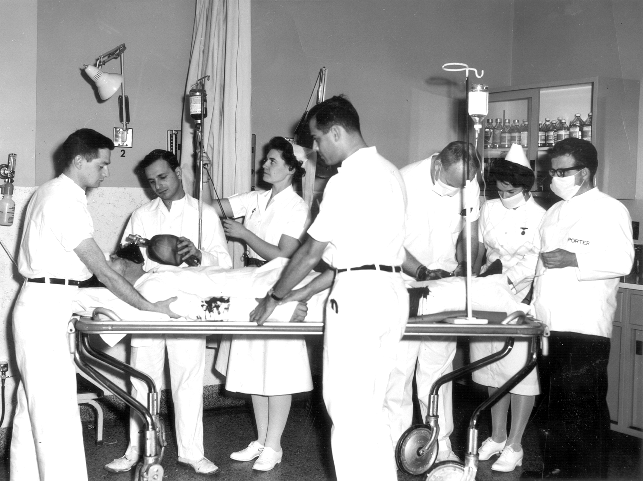 Members of the care team and a patient. Dr. Wilbert J. Keon stands at the head.