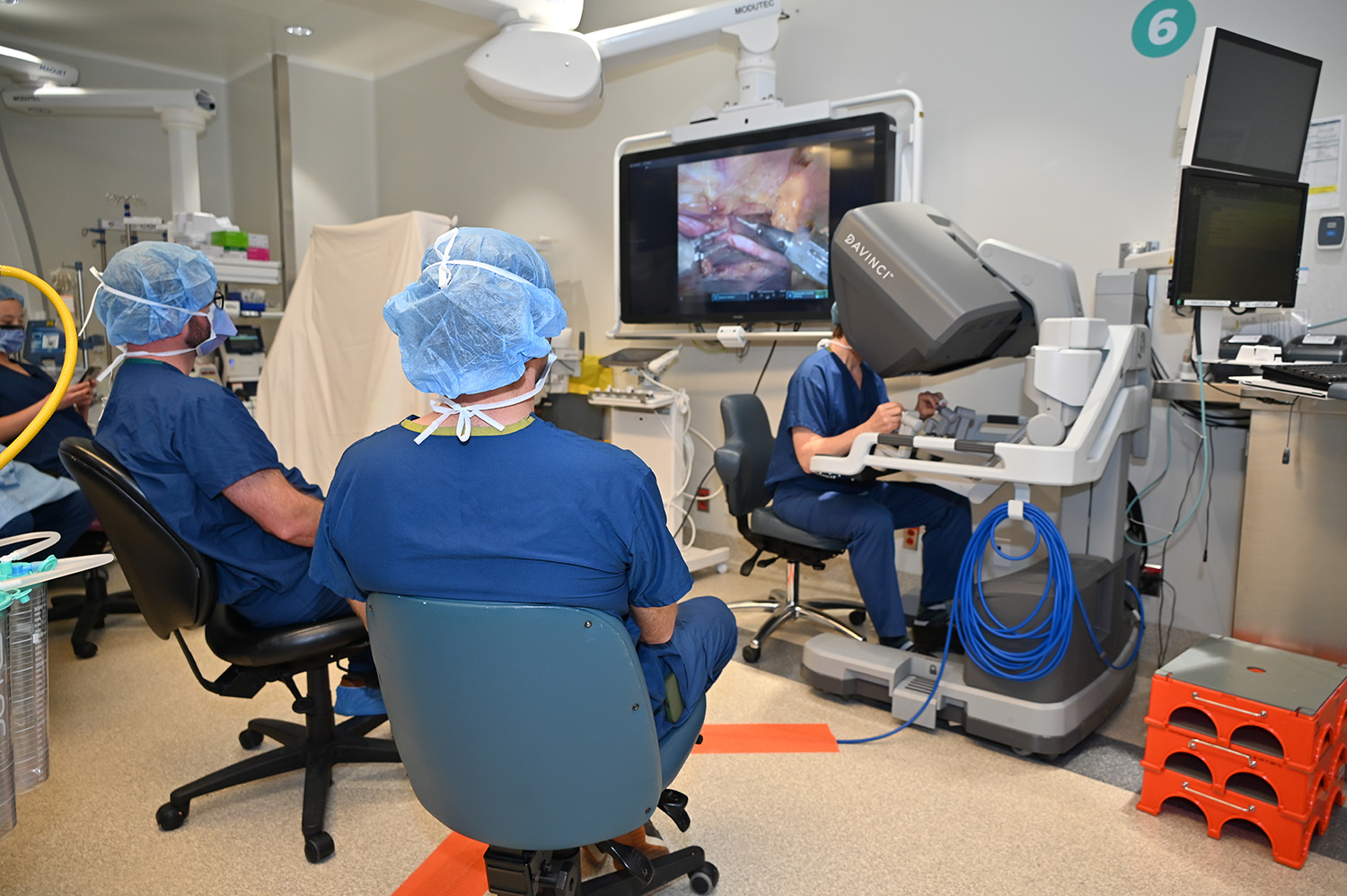 Les Drs Gennady Atroshchenko (au centre) et Joseph T. McGinn (à gauche) observent le Dr Marc Ruel (à droite) qui manipule avec précision le robot chirurgical da Vinci.