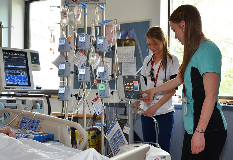 Deux travailleuses de la santé opèrent un instrument de refroidissement de patient.