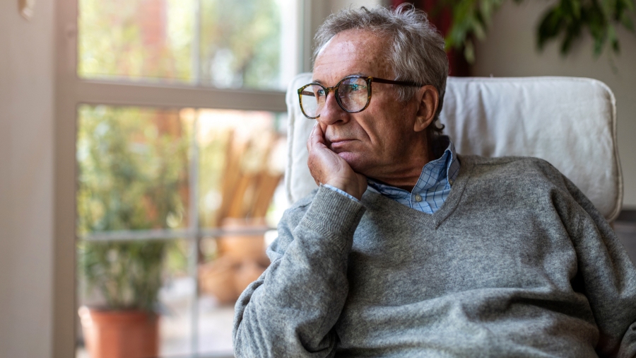 man looking out of window at home