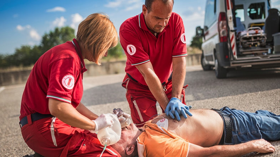 Two emergency workers tend to a victim of cardiac arrest