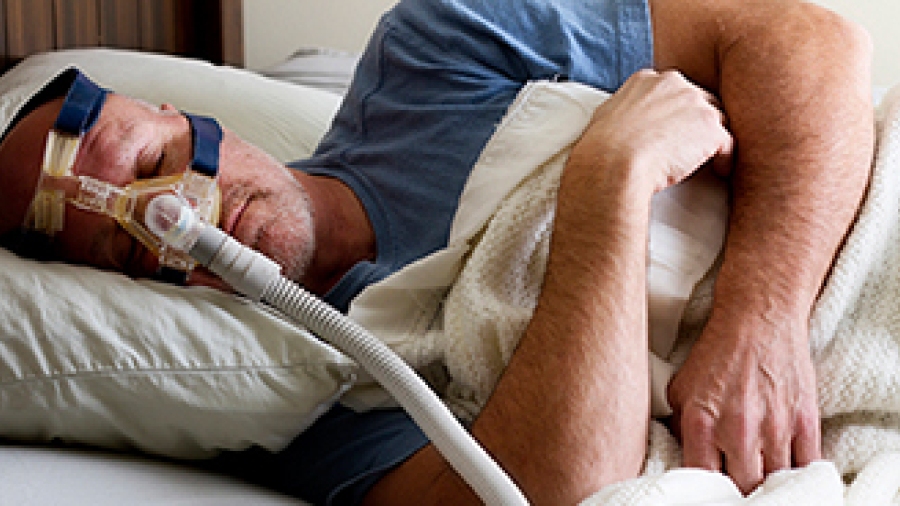 Man wearing continuous positive airway pressure (CPAP) machine to treat sleep apnea