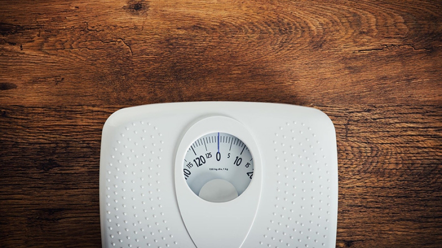 A body scale on a wooden floor