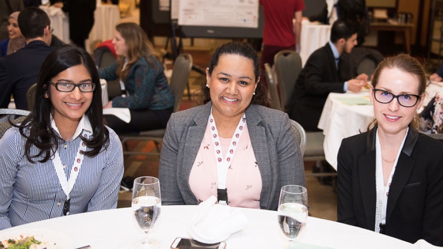 Three women smiling women sitting at a table