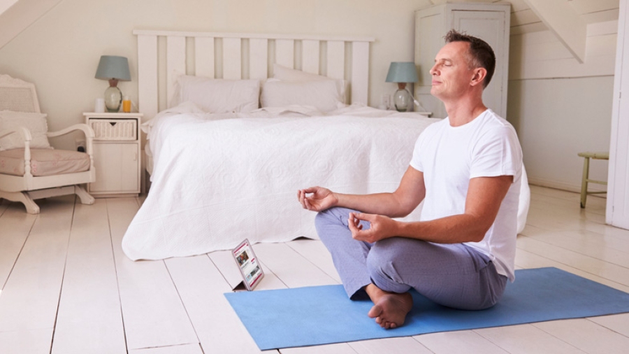 A man meditating in his bedroom