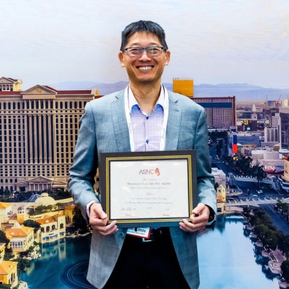 Dr. Benjamin Chow, holding an award certificate.