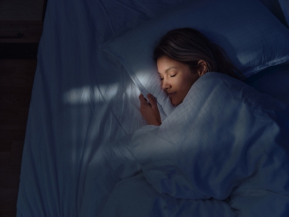 Above view of woman sleeping in bed at night