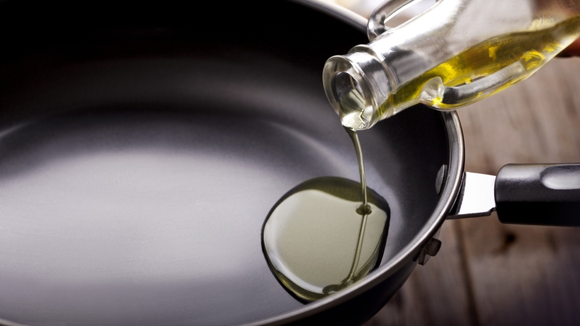 Pouring olive oil in frying pan