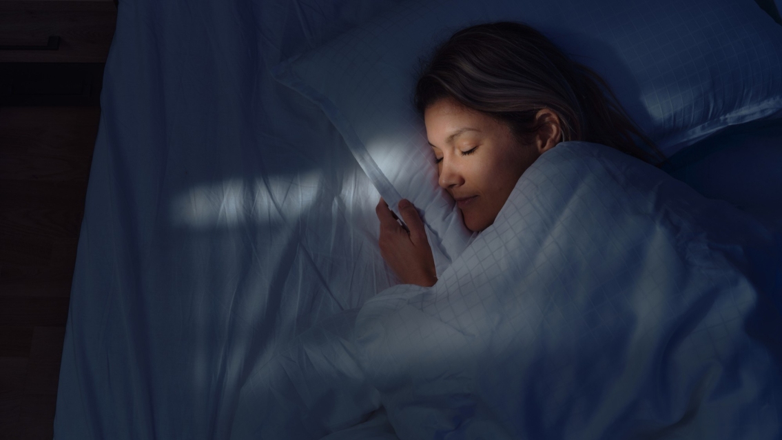 Above view of woman sleeping in bed at night