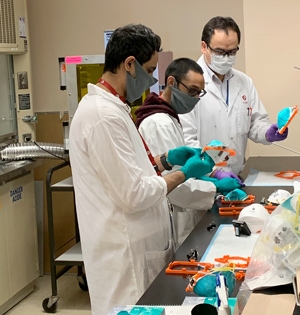 Doctors at the Heart Institute prepare N95 surgical face masks for decontamination using a photothermal device.